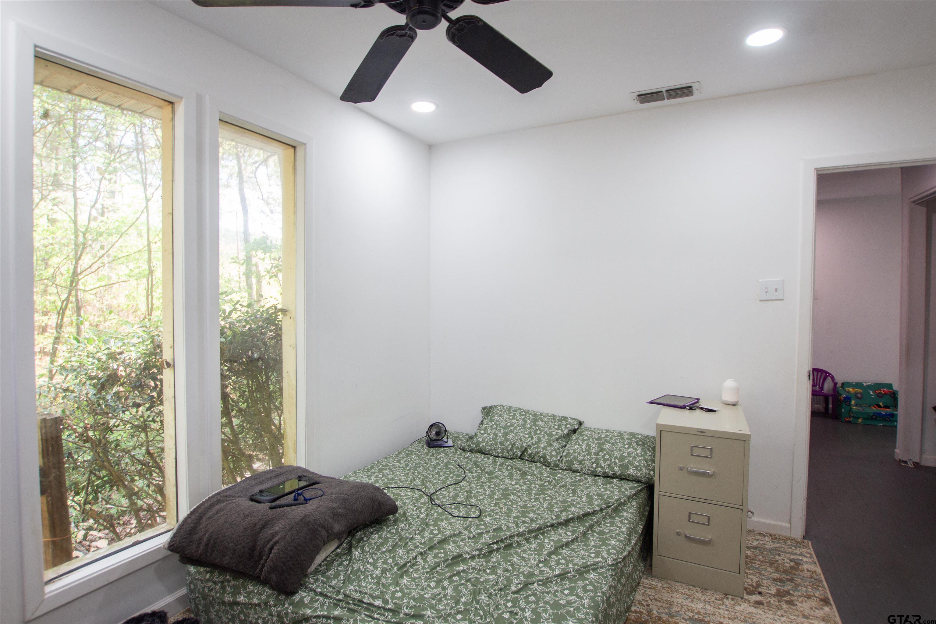 2942 Medlin Road Gilmer, TX 75645 - Photo 23 of 30 a bedroom with a bed and a large window