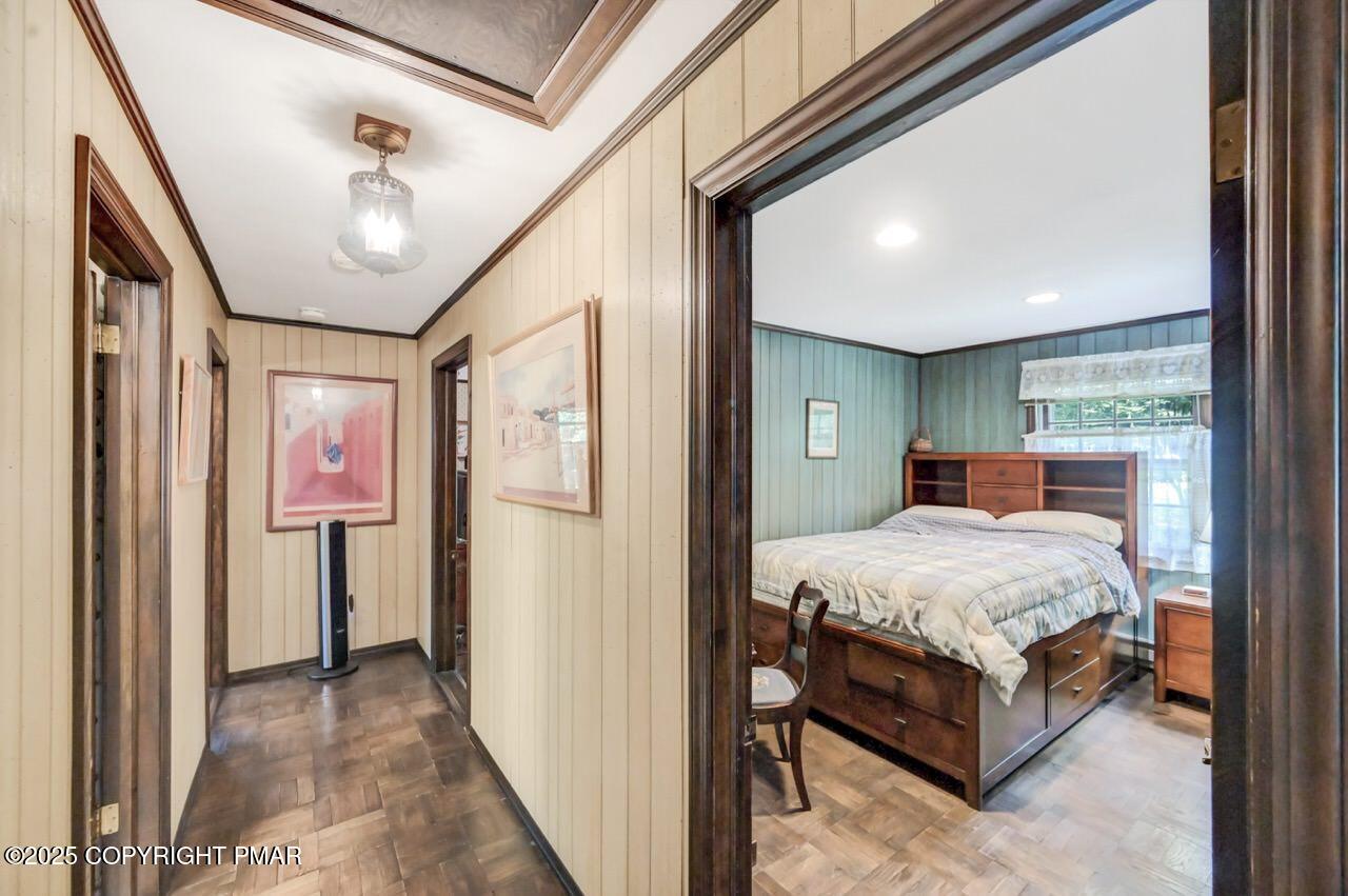 5142 Pine Tree Road Pocono Summit, PA 18346 - Photo 42 of 57 a spacious bedroom with a large bed and a chandelier