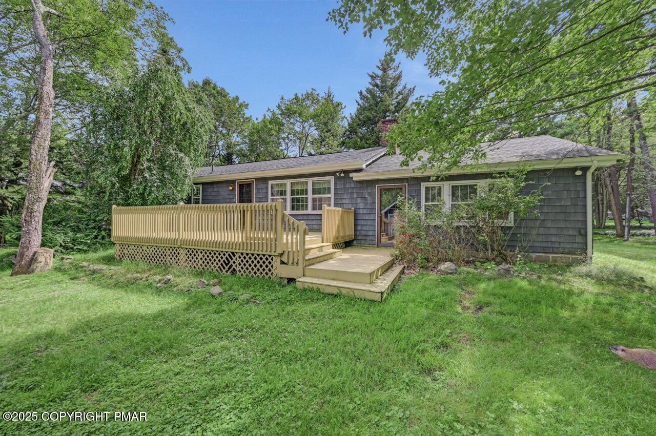 5142 Pine Tree Road Pocono Summit, PA 18346 - Photo 5 of 57 a view of a house with a backyard and a patio