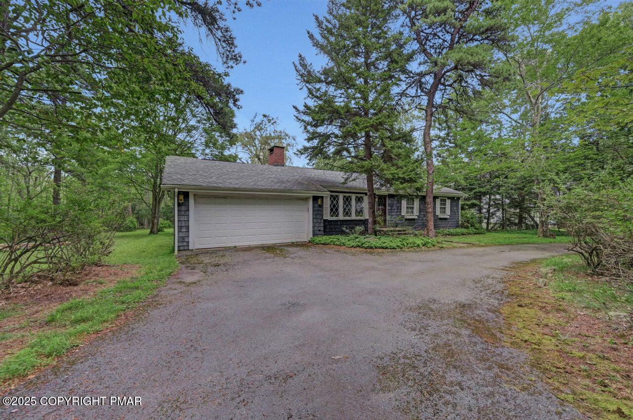 5142 Pine Tree Road Pocono Summit, PA 18346 - Photo 56 of 57 a front view of a house with a yard and garage