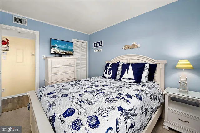 a bedroom with a bed and a tv on dresser