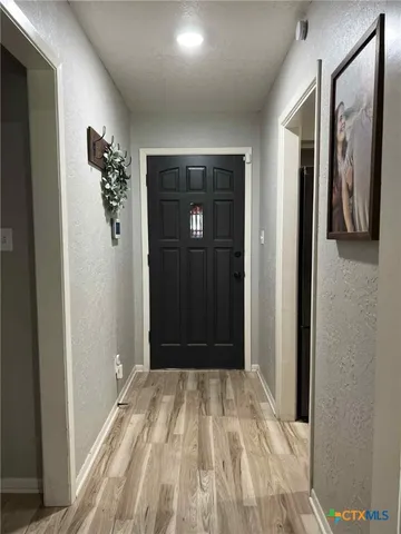 a view of a hallway with wooden floor and closet