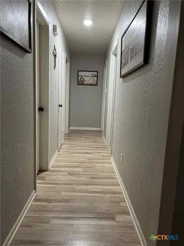 a view of a hallway with wooden floor