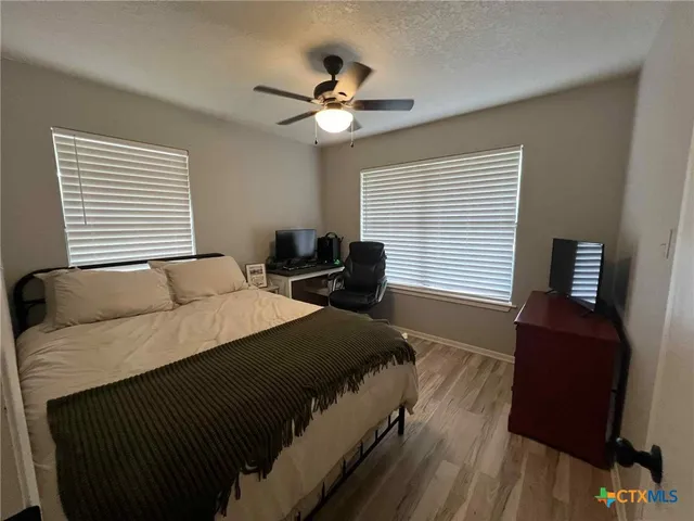 a bedroom with a bed and wooden floor