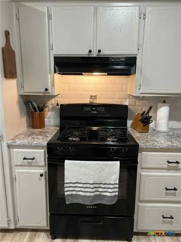 a stove top oven sitting inside of a kitchen