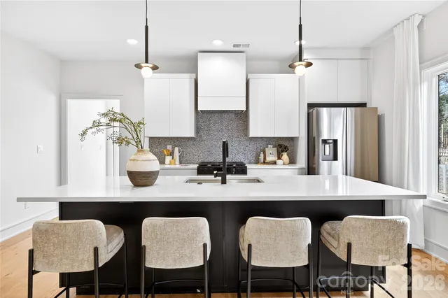 a kitchen with a dining table chairs refrigerator and cabinets
