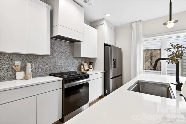 a kitchen with a stove a refrigerator and a sink