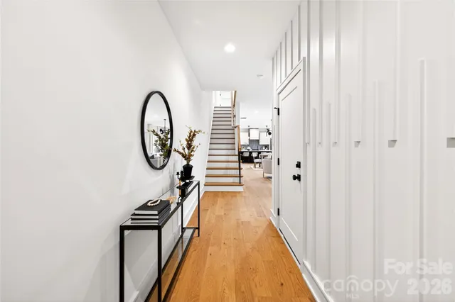 a view of a hallway with wooden floor and staircase