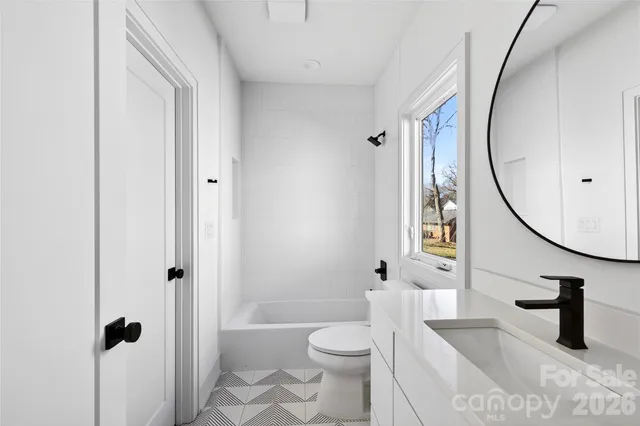 a bathroom with a sink a toilet and a mirror