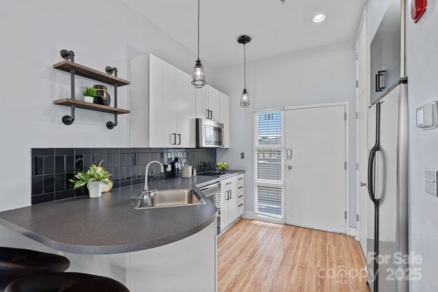 a kitchen with stainless steel appliances granite countertop a sink refrigerator and microwave