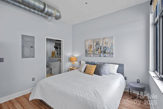 a bedroom with a bed and a painting on the wall