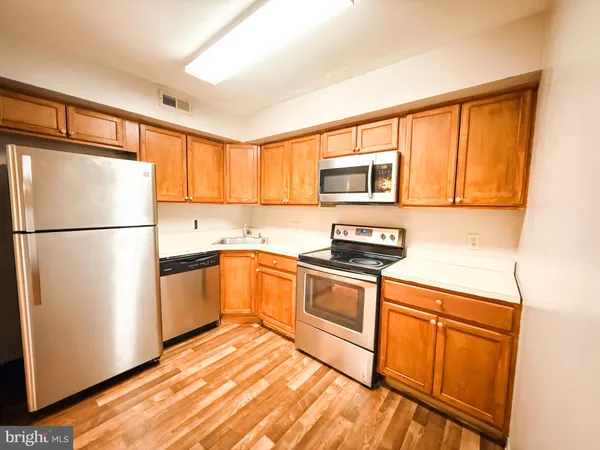 a kitchen with granite countertop a refrigerator stove top oven and sink