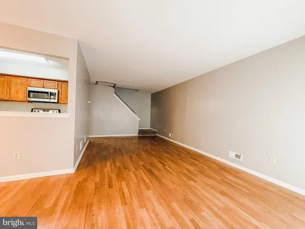 a view of empty room with wooden floor
