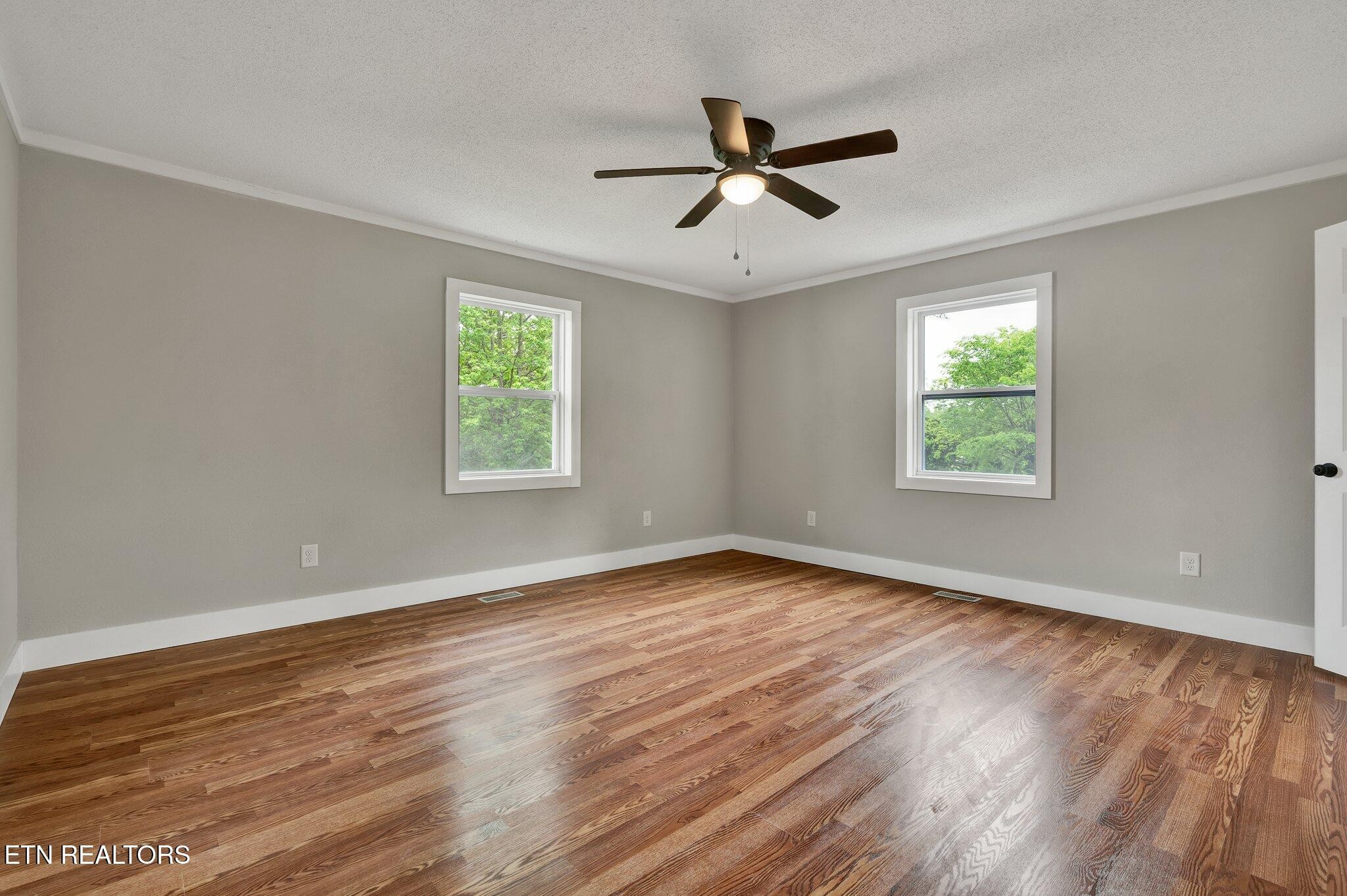12408 North Nopone Valley Road Decatur, TN 37322 - Photo 23 of 54 a view of empty room with wooden floor and fan