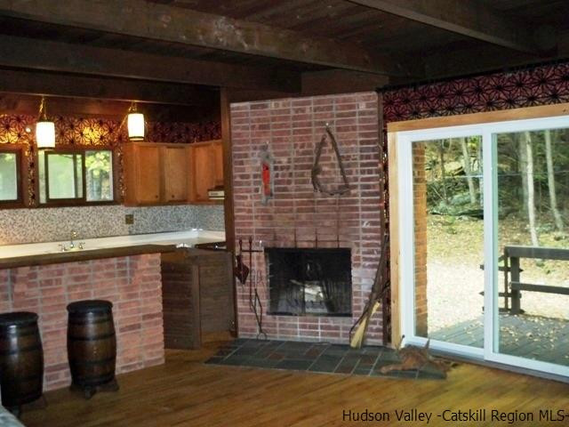 357 Deer Run Road Roxbury, NY 12421 - Photo 6 of 18 a living room with a fireplace and a floor to ceiling window