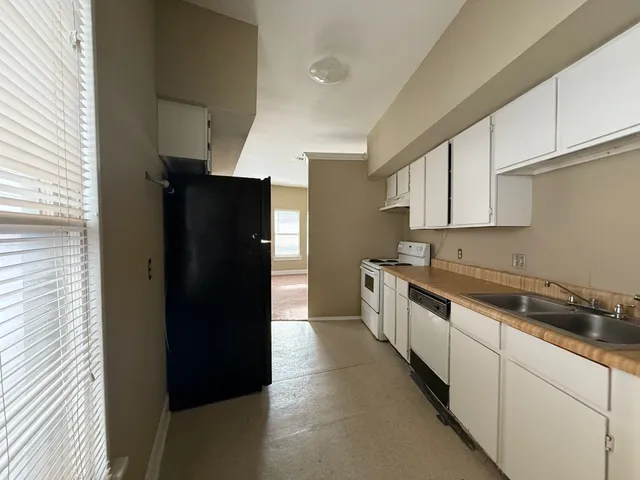 a kitchen with a refrigerator and cabinets