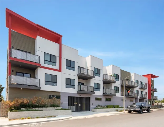 an empty room with wooden floor chandelier and windows