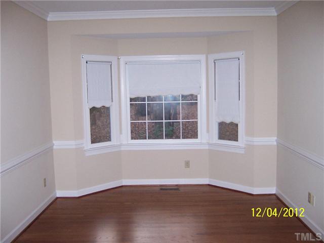 7709 Lambroll Lane Raleigh, NC 27613 - Photo 12 of 18 a view of an empty room with wooden floor and a window