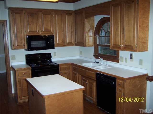 7709 Lambroll Lane Raleigh, NC 27613 - Photo 10 of 18 a kitchen with a sink and a stove top oven