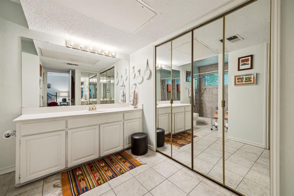 9222 Church Road, Unit 108 Dallas, TX 75231 - Photo 11 of 27 a spacious bathroom with a mirror a shower and sink