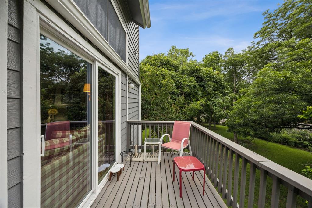 9222 Church Road, Unit 108 Dallas, TX 75231 - Photo 25 of 27 a balcony with wooden floor and outdoor seating