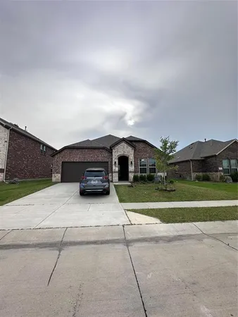 a car parked in front of a house with a yard