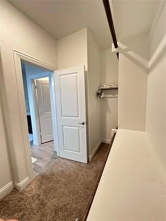 a view of a hallway with closet and wooden floor