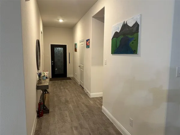 a view of a hallway with wooden floor and closet