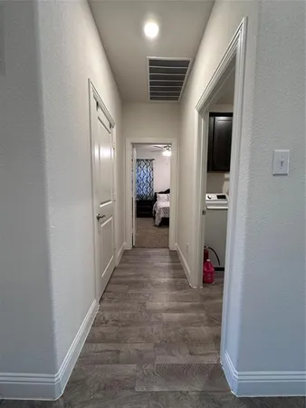 a view of a hallway with wooden floor and furniture