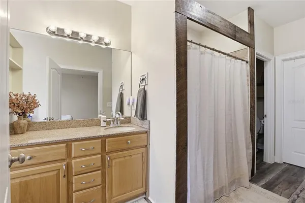 a bathroom with a granite countertop sink tub and a mirror