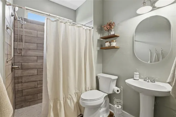 a bathroom with a sink a toilet and a mirror