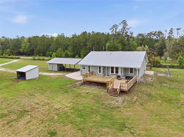 a view of a swimming pool with a yard and a large tree