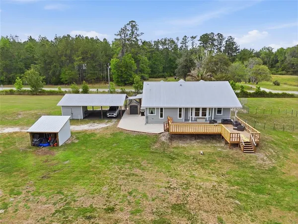 an aerial view of a house with a yard basket ball court and outdoor seating