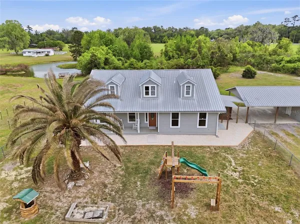 an aerial view of residential houses with outdoor space and river