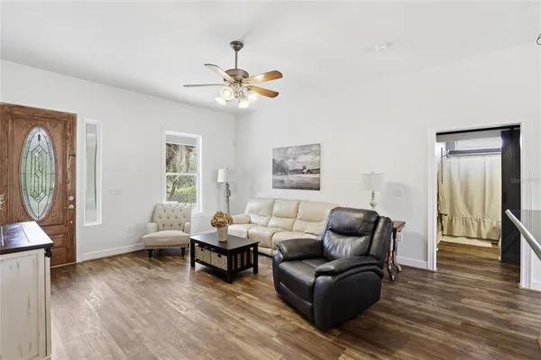 a living room with furniture and a wooden floor