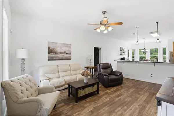 a living room with furniture a chandelier and a window