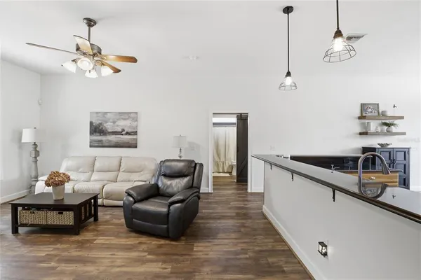 a kitchen with stainless steel appliances kitchen island granite countertop a stove a sink a refrigerator dining table and chairs