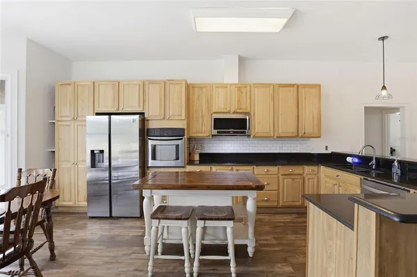 a kitchen with stainless steel appliances granite countertop a sink a stove and a microwave