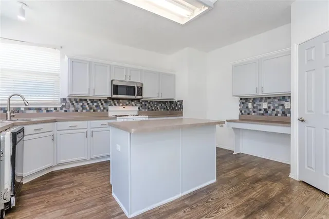 a kitchen with white cabinets and appliances