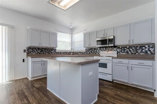 a kitchen with granite countertop white cabinets and stainless steel appliances