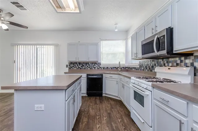 a kitchen with stainless steel appliances granite countertop a sink stove and cabinets