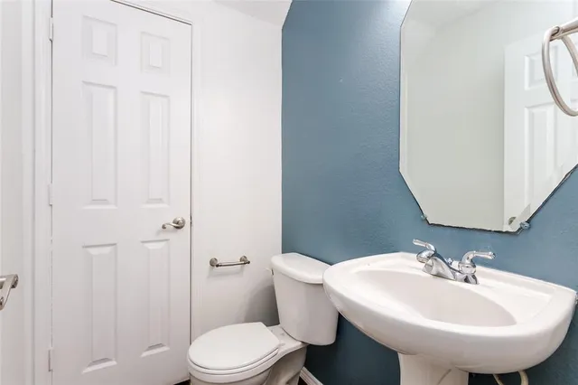 a bathroom with a sink toilet and a mirror