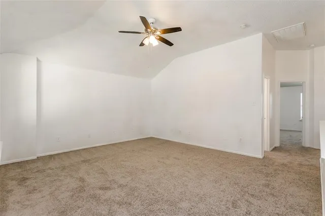 an empty room with a ceiling fan and a window