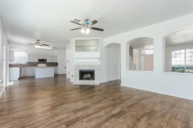 a view of a livingroom with a fireplace a chandelier and wooden floor