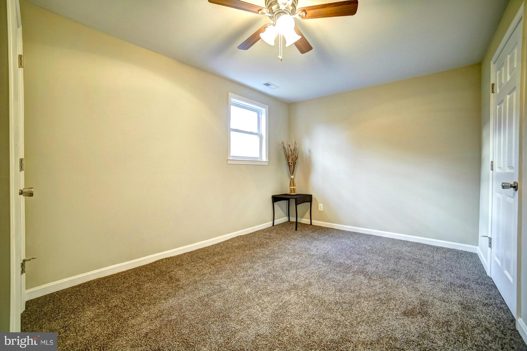3811 Longley Road Abingdon, MD 21009 - Photo 17 of 21 an empty room with a chandelier fan and windows