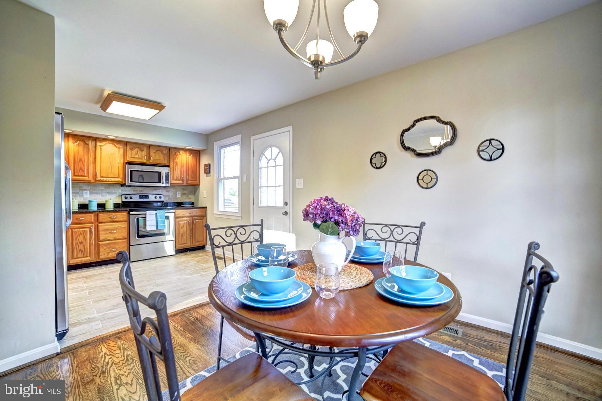 3811 Longley Road Abingdon, MD 21009 - Photo 5 of 21 a view of a dining room with furniture a kitchen and a chandelier
