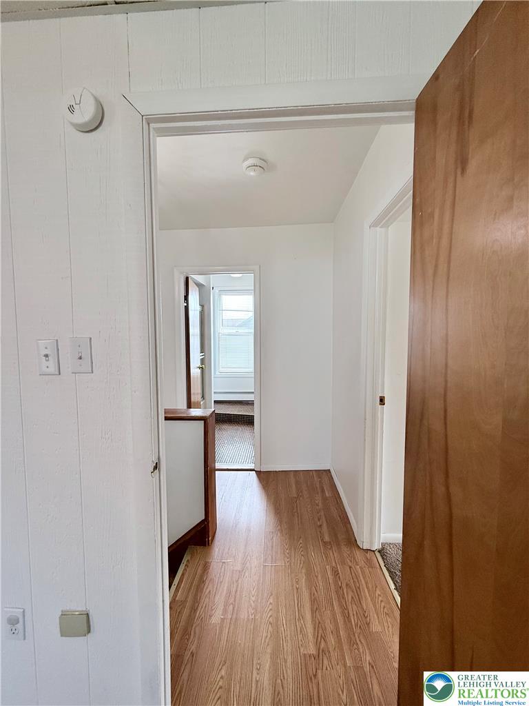 5540 Main Street Whitehall, PA 18052 - Photo 31 of 53 A well-maintained hallway with warm wood flooring invites movement through this residence.