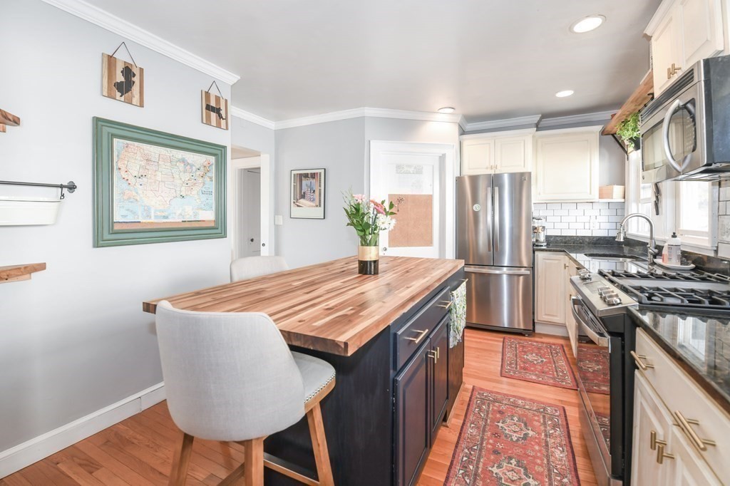 27 Fuller Road, Unit 27 Watertown, MA 02472 - Photo 5 of 13 a kitchen with stainless steel appliances granite countertop a stove a refrigerator a sink dishwasher with a dining table and chairs