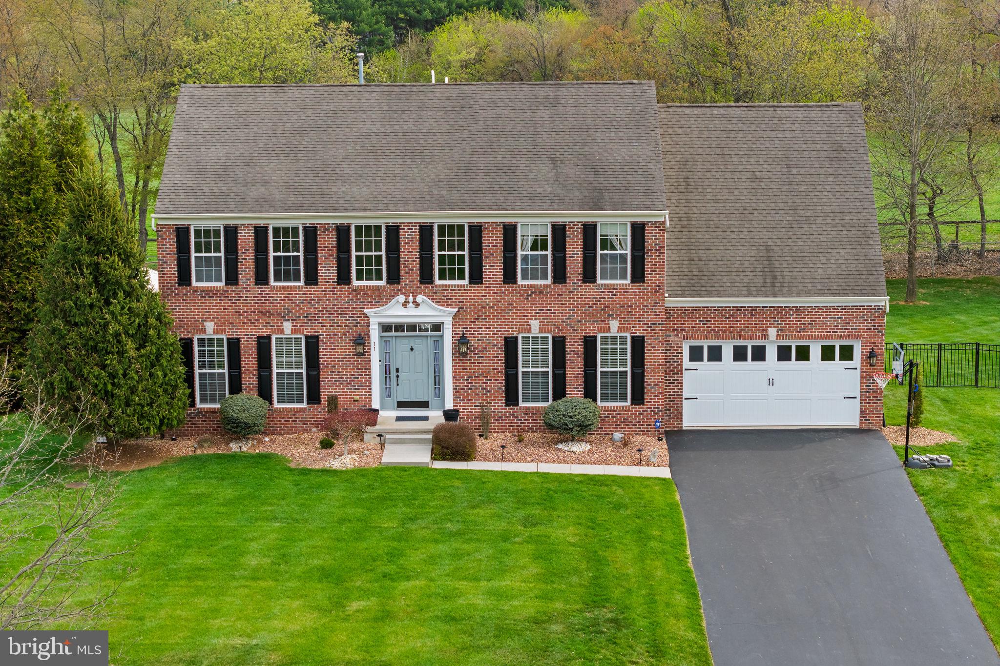 Charming brick home with lush greenery.