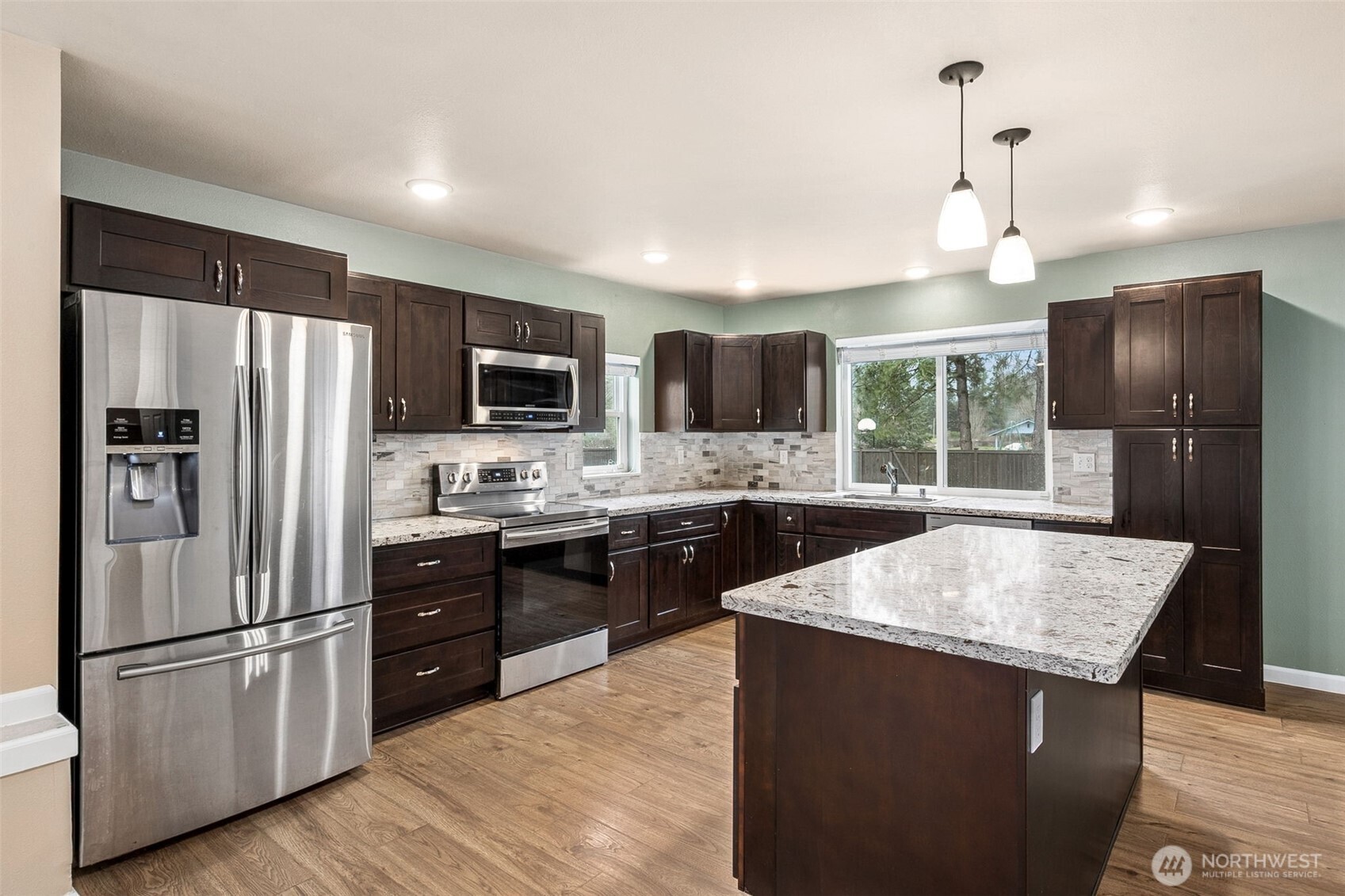 101 Murphy Lane South Rainier, WA 98576 - Photo 7 of 40 a kitchen with stainless steel appliances granite countertop a refrigerator a sink dishwasher a stove top oven a refrigerator with island and chairs